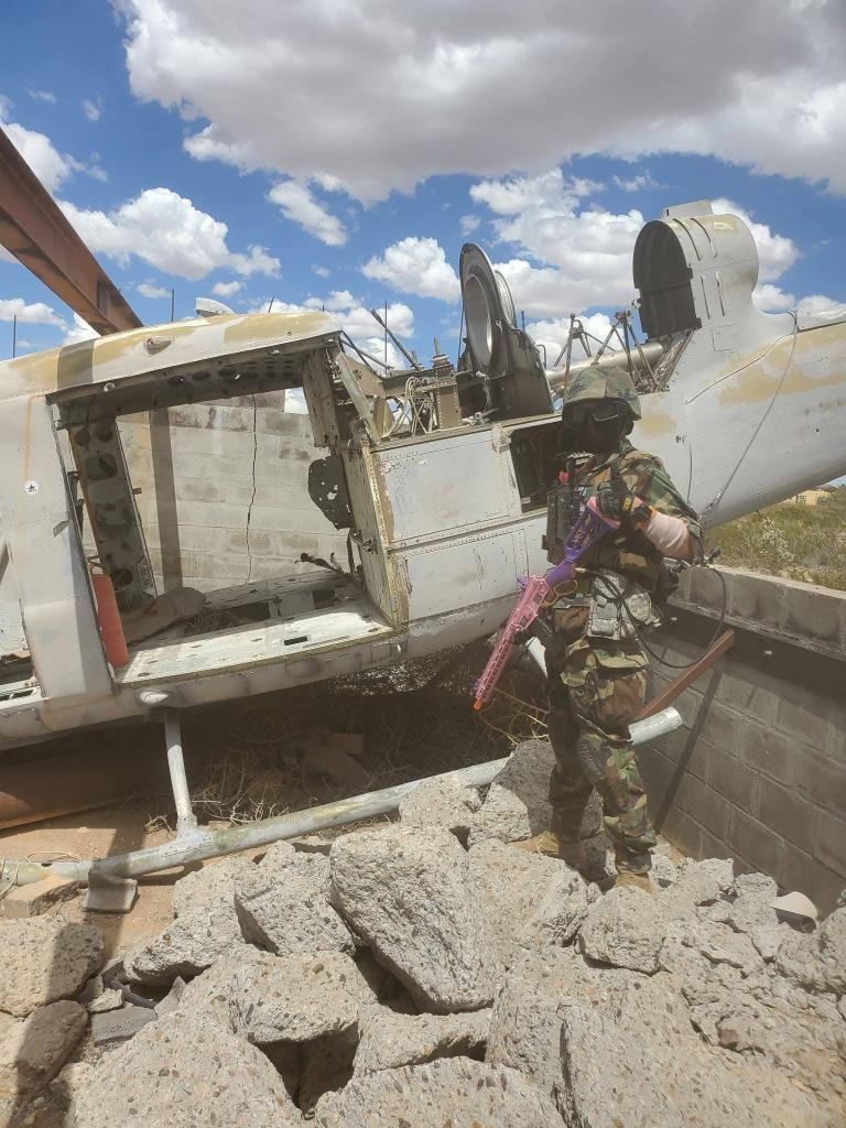 Player with airsoft rifle next to helicopter wreckage at Copperhead XI