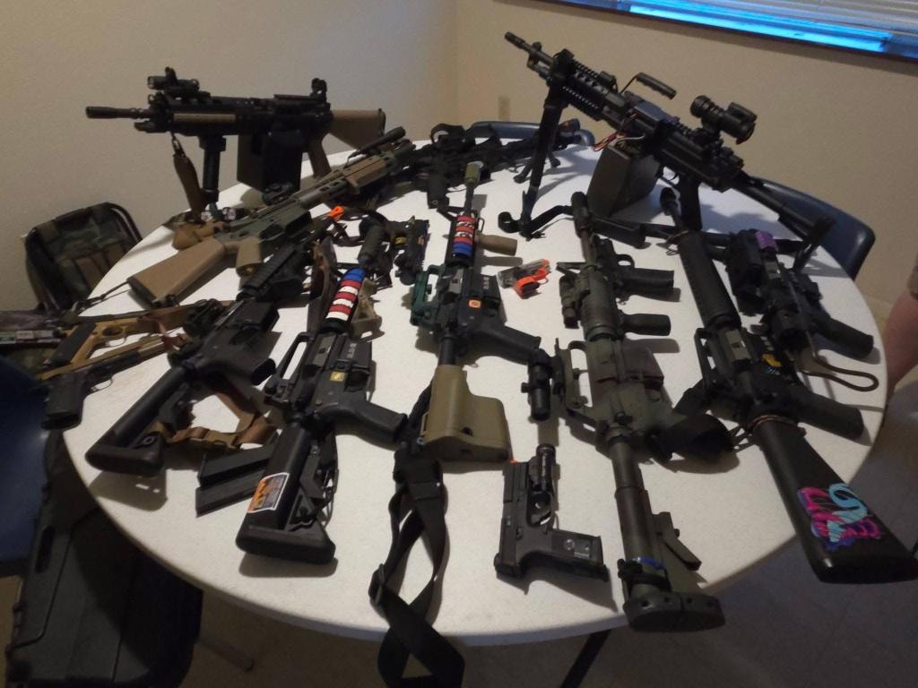 Airsoft rifles and equipment laid out on a table at Copperhead XI